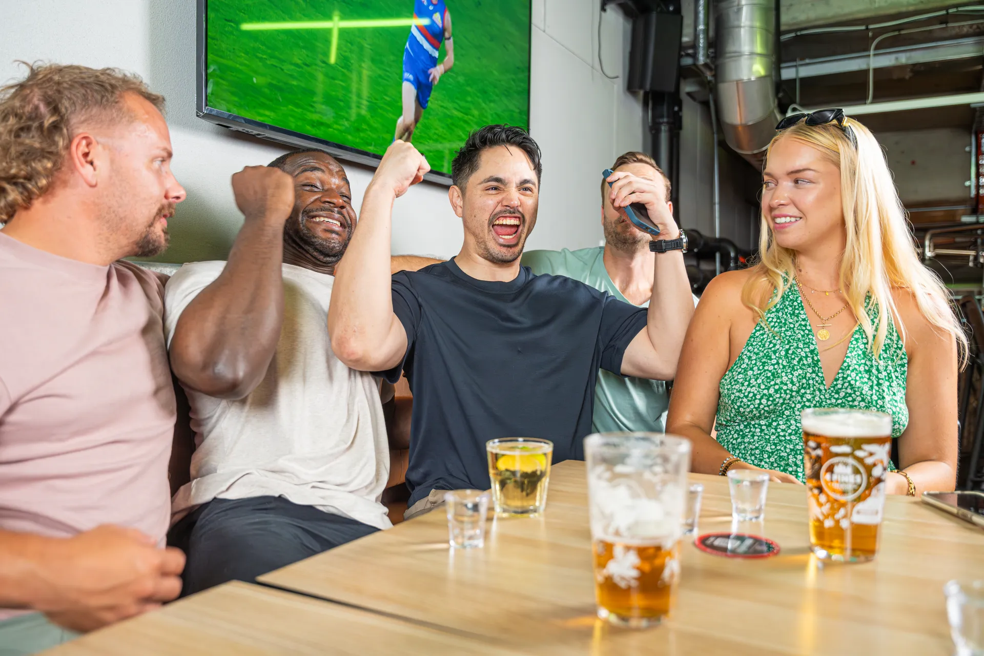 Mates cheering live sport at the pub with the Sport Insights app